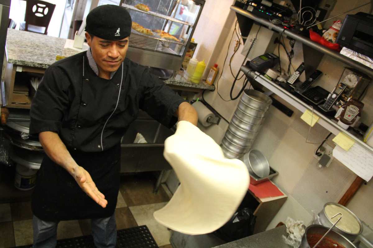 Francisco Duran prepares the first pizza pie of the day.
