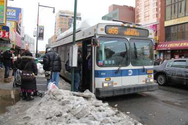 Flushing serves as a major transportation hub, with throngs of people transferring between buses and trains.