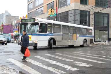 Flushing serves as a major transportation hub, with throngs of people transferring between buses and trains.