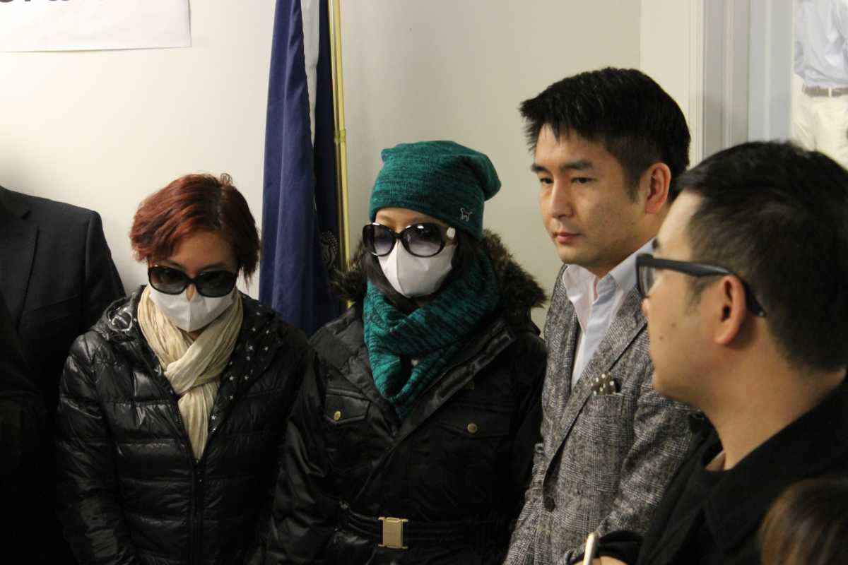 The 16-year-old slashing victim (in blue) appeared beside her mother at the press conference and spoke through an interpreter (at right).