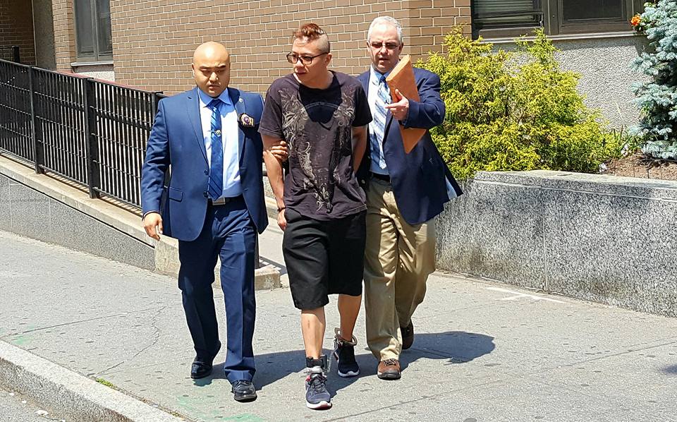 Detectives escort Wilson Lai, a suspect in the slashing of a girl in Whitestone last December, from the 109th Precinct stationhouse in Flushing.