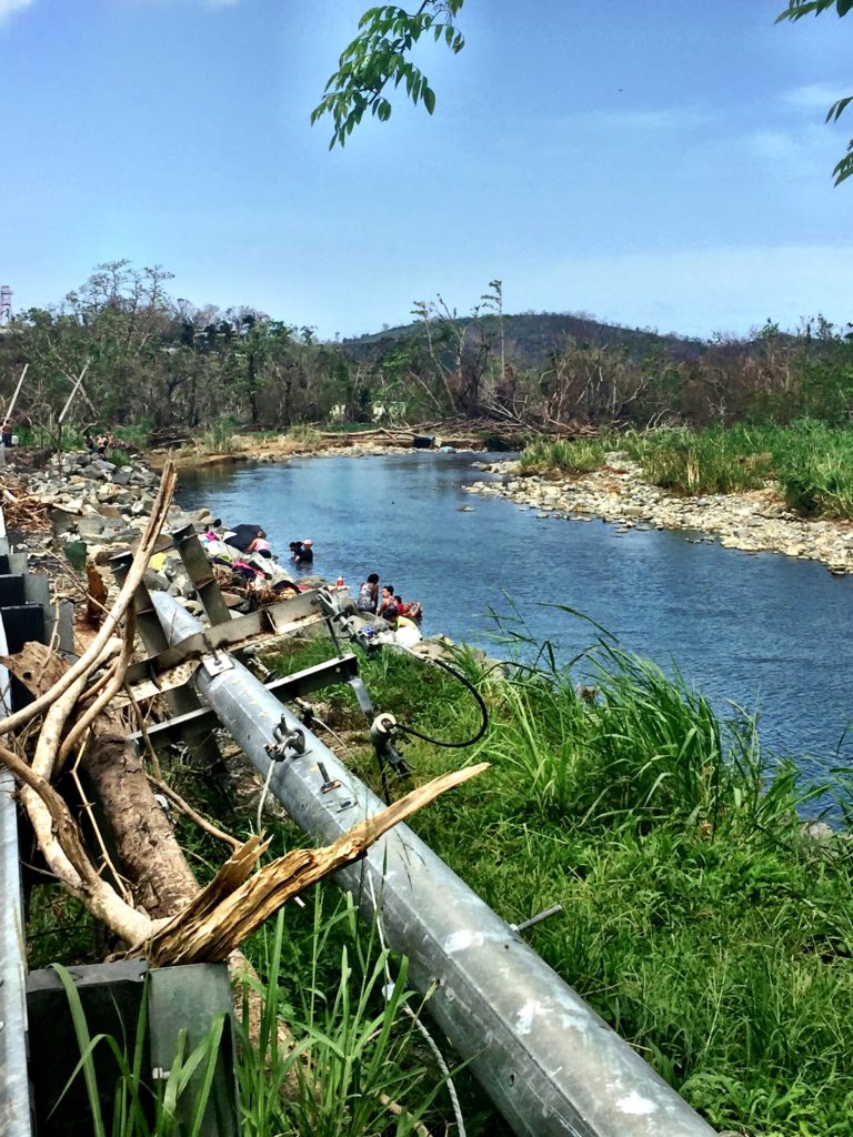 Families wash their clothes in a stream. 
