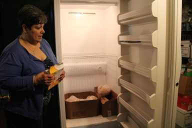 A member of Sacred Heart Food Pantry in Glendale stands next to an empty refrigerator in this 2014 photo.