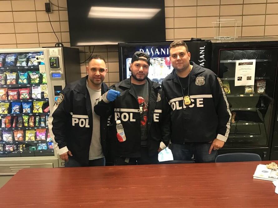 Members of the 112th Precinct holding an improvised mailbox fishing device seized during a May 4 arrest.