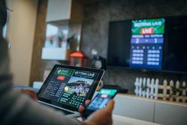 Man watches soccer game and bets in his living room