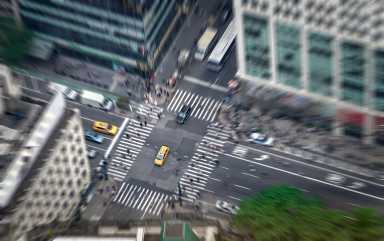 New York city street full of taxis, cars and pedestrians. Yellow cab in focus. Busy NYC Downtown. Crowd of people crossing crosswalks. Traffic jam in NY.
