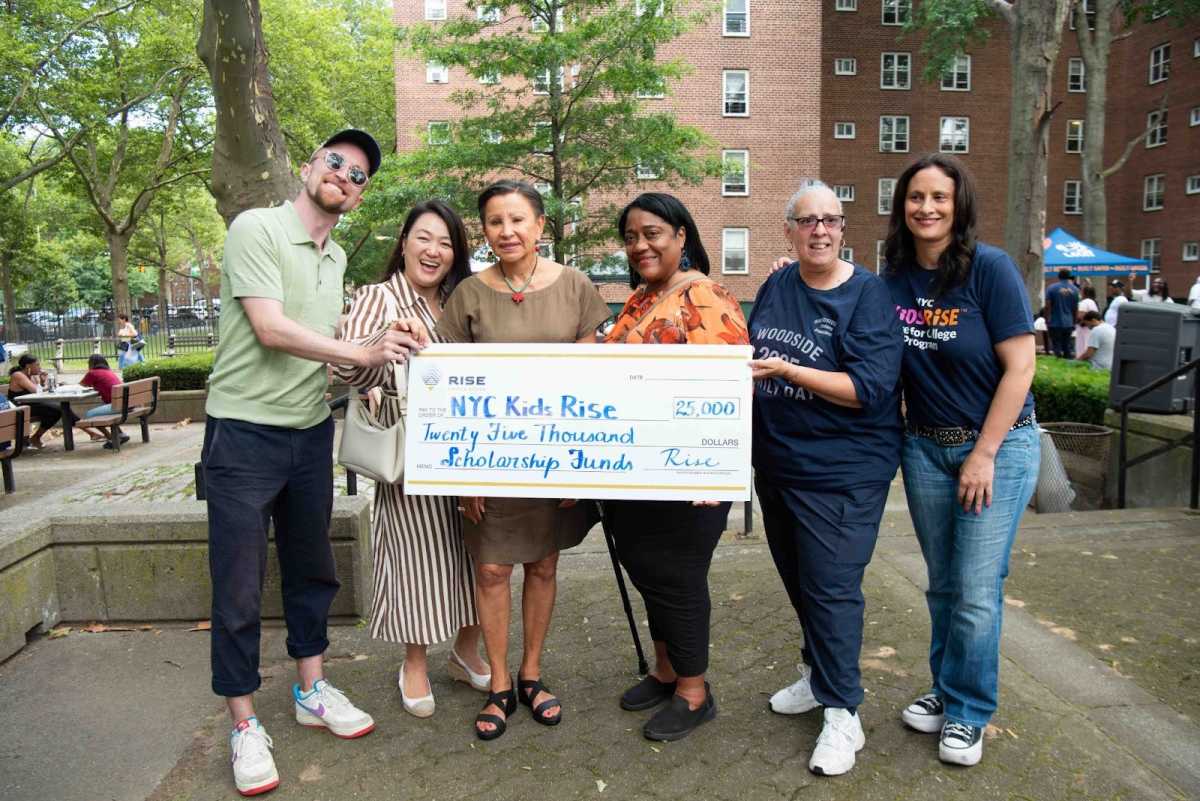 Rise Light & Power Director of External Affairs Wil Fisher, Council Member Julie Won, Congresswoman Nydia Velásquez, P.S. 151Q Parent Coordinator Naida Ryans, Woodside Houses Resident Association President Tammy Reyes, and NYC Kids RISE Founding Executive Director Debra-Ellen Glickstein celebrate the $25,000 Rise Light & Power Community Scholarship 2025 at Woodside Houses Family Day (July 19, 2025). Photo by Bridget Ye for NYC Kids RISE.